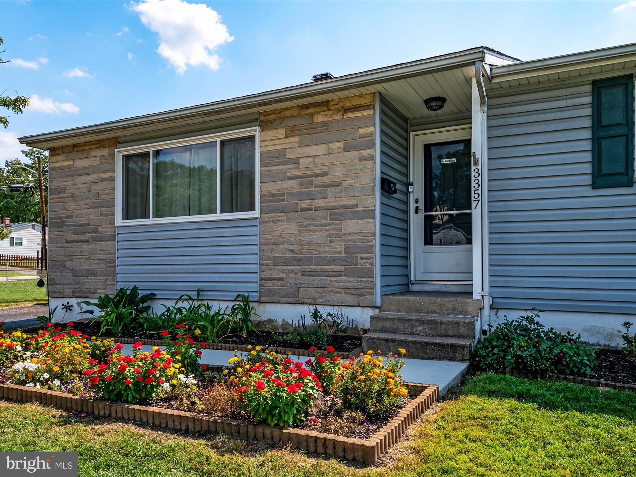 a front view of a house with a yard and outdoor seating