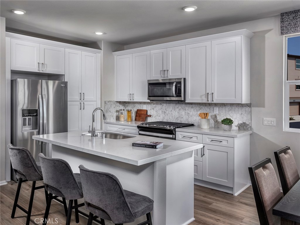 a kitchen with a dining table chairs refrigerator and cabinets