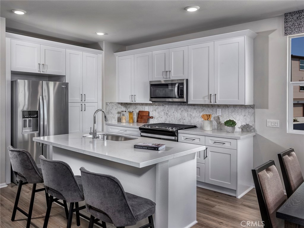 a kitchen with a dining table chairs refrigerator and cabinets