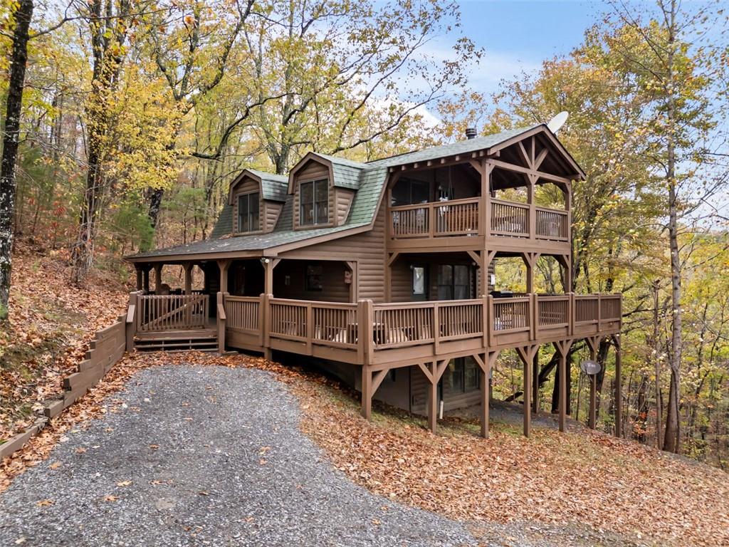 a view of a house with a yard balcony and wooden fence