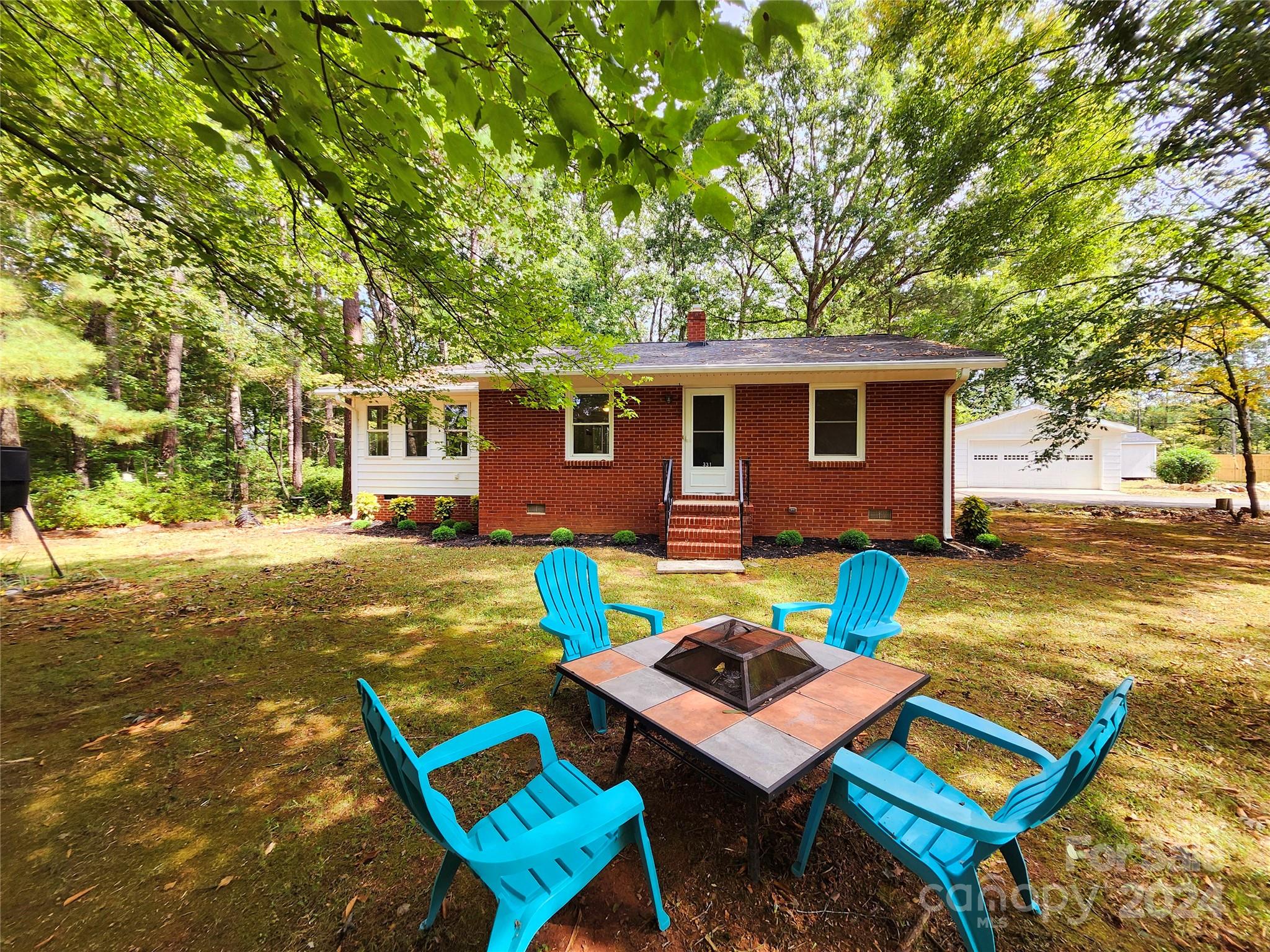 a backyard of a house with barbeque oven table and chairs