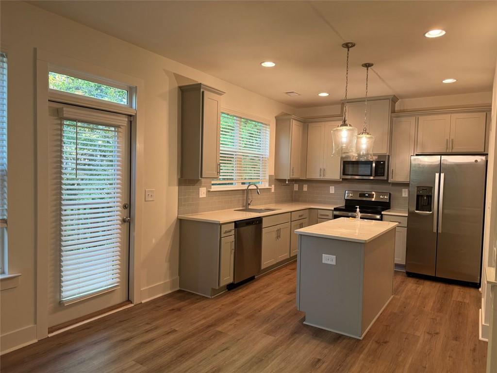 a kitchen with refrigerator cabinets and wooden floor