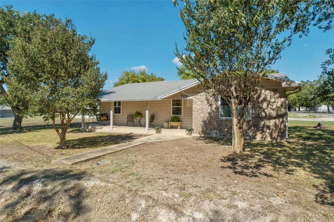 a view of a house with a yard and tree