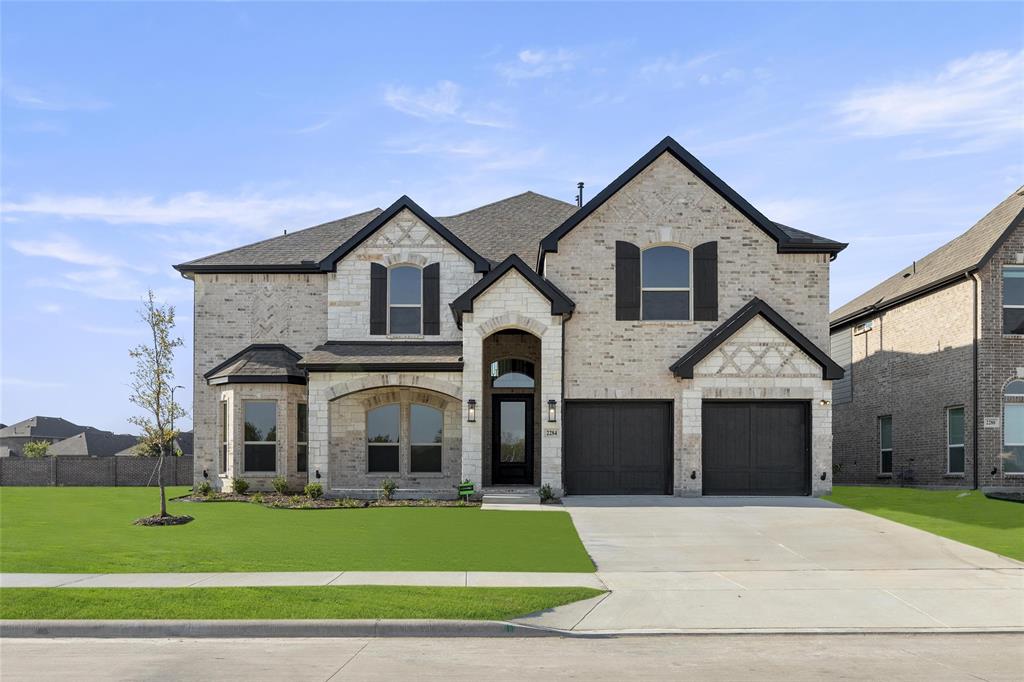 a front view of a house with a yard and garage