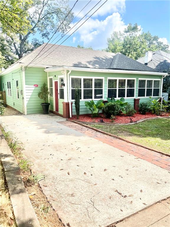 a front view of a house with a yard and potted plants