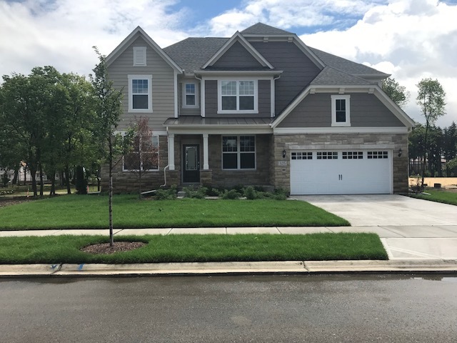 a front view of a house with a garden and plants