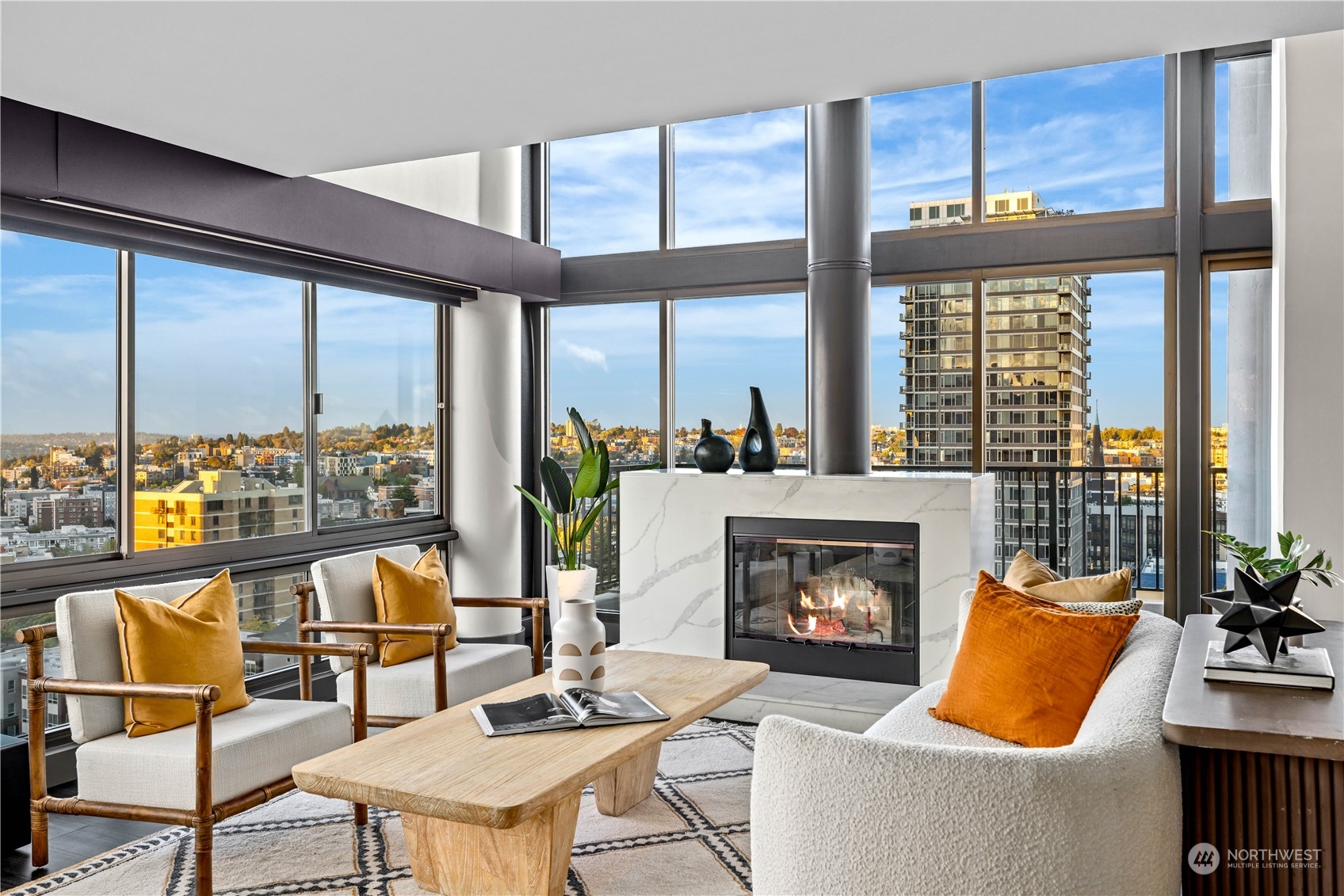 a living room with furniture a fireplace and floor to ceiling windows