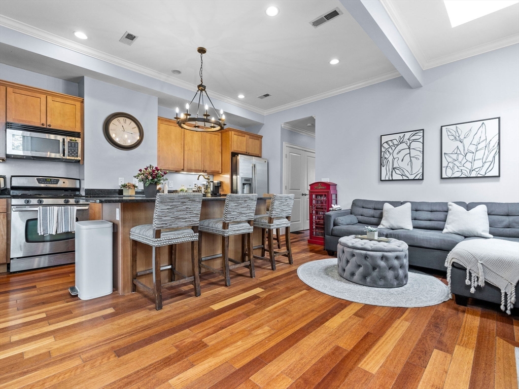 a living room with furniture a clock and a view of kitchen