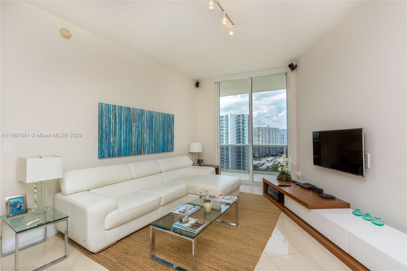 a living room with furniture a flat screen tv and a large window