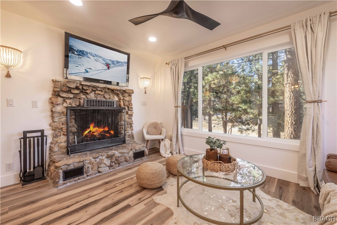 a living room with furniture a fireplace and a large window