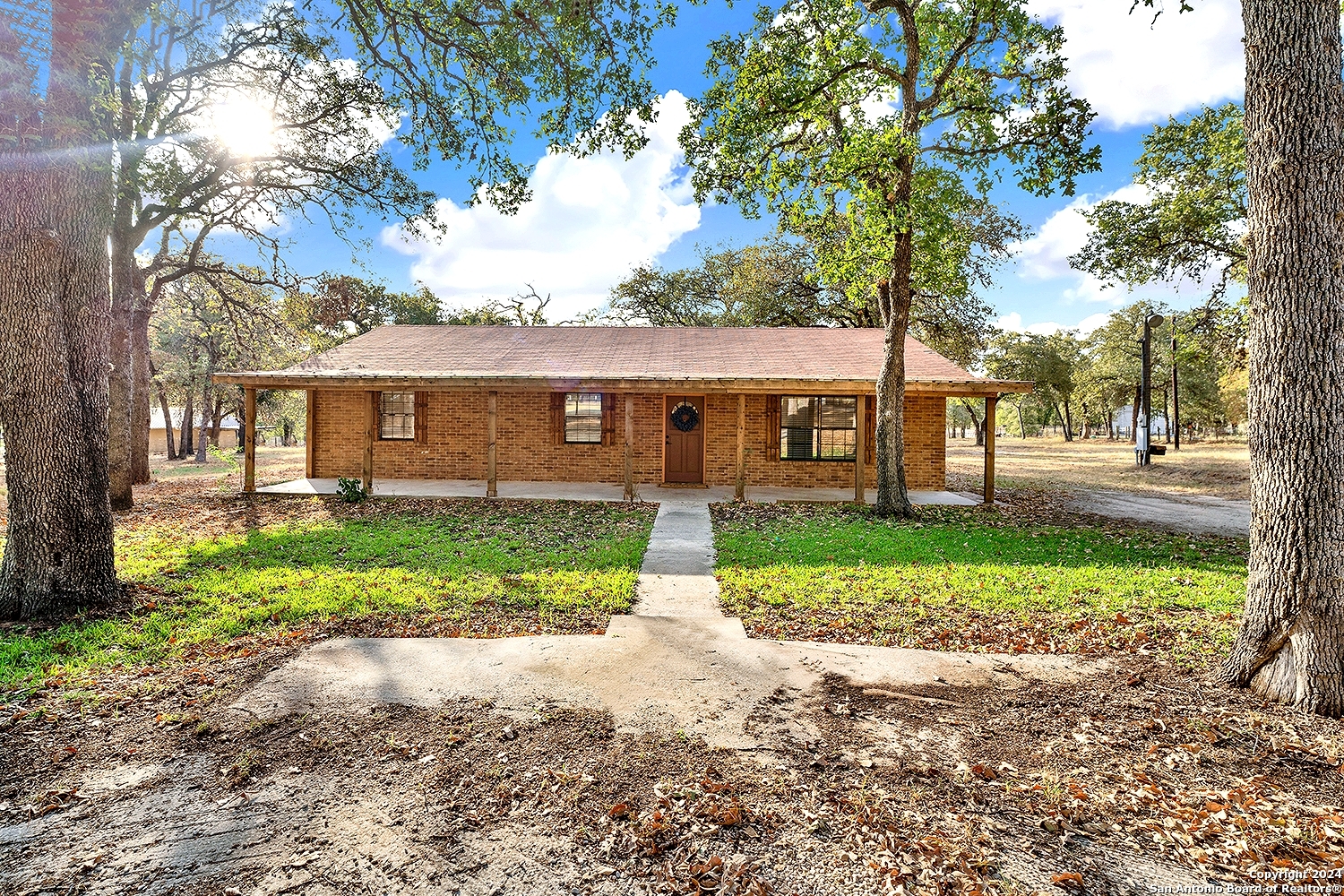 a front view of a house with a yard and lake view