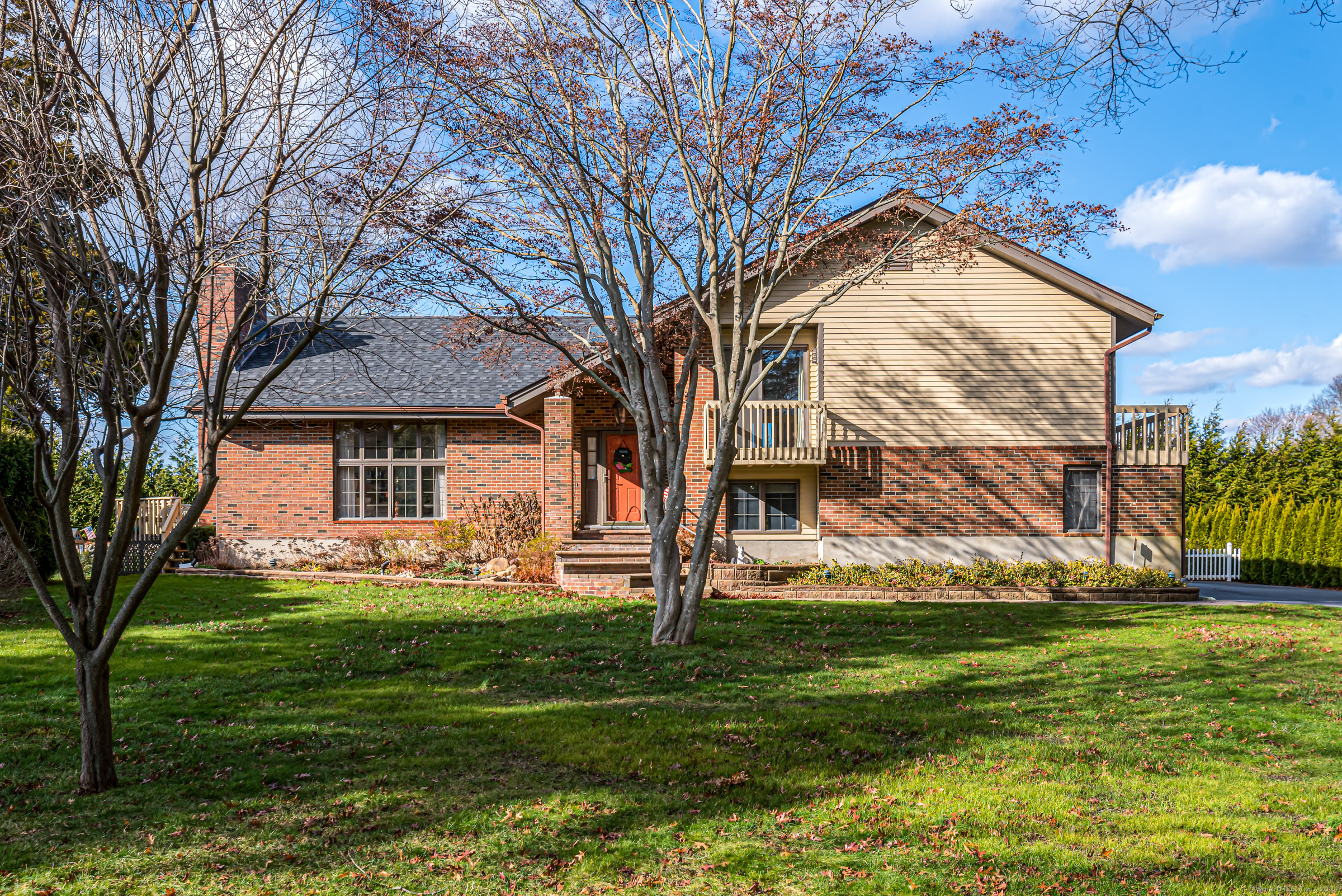 a front view of a house with a yard and trees