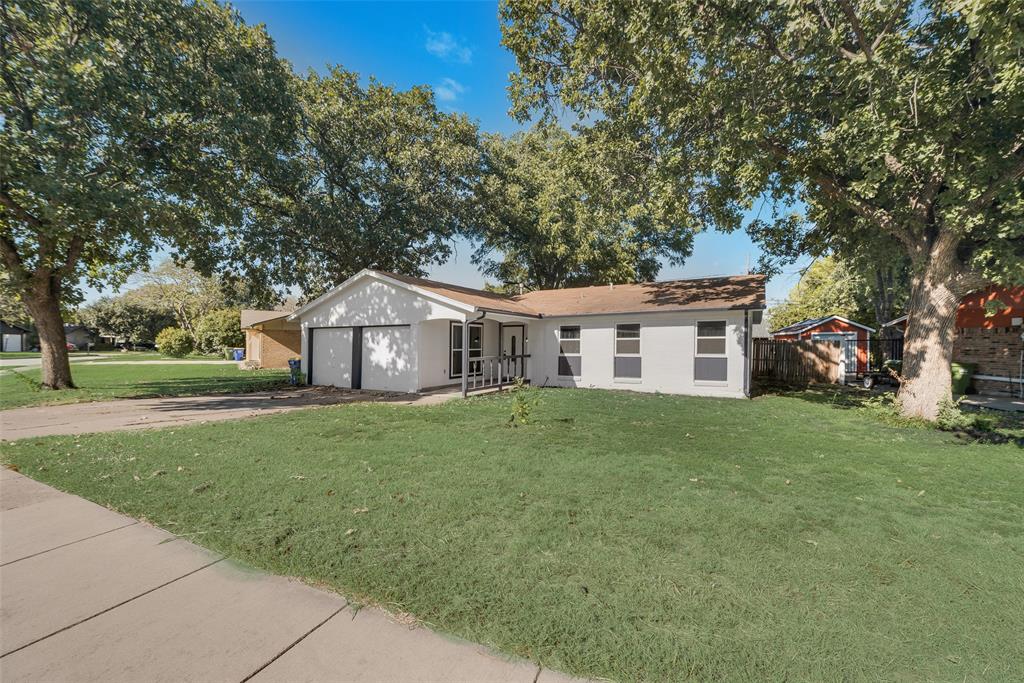 Single story home featuring a garage and a front yard