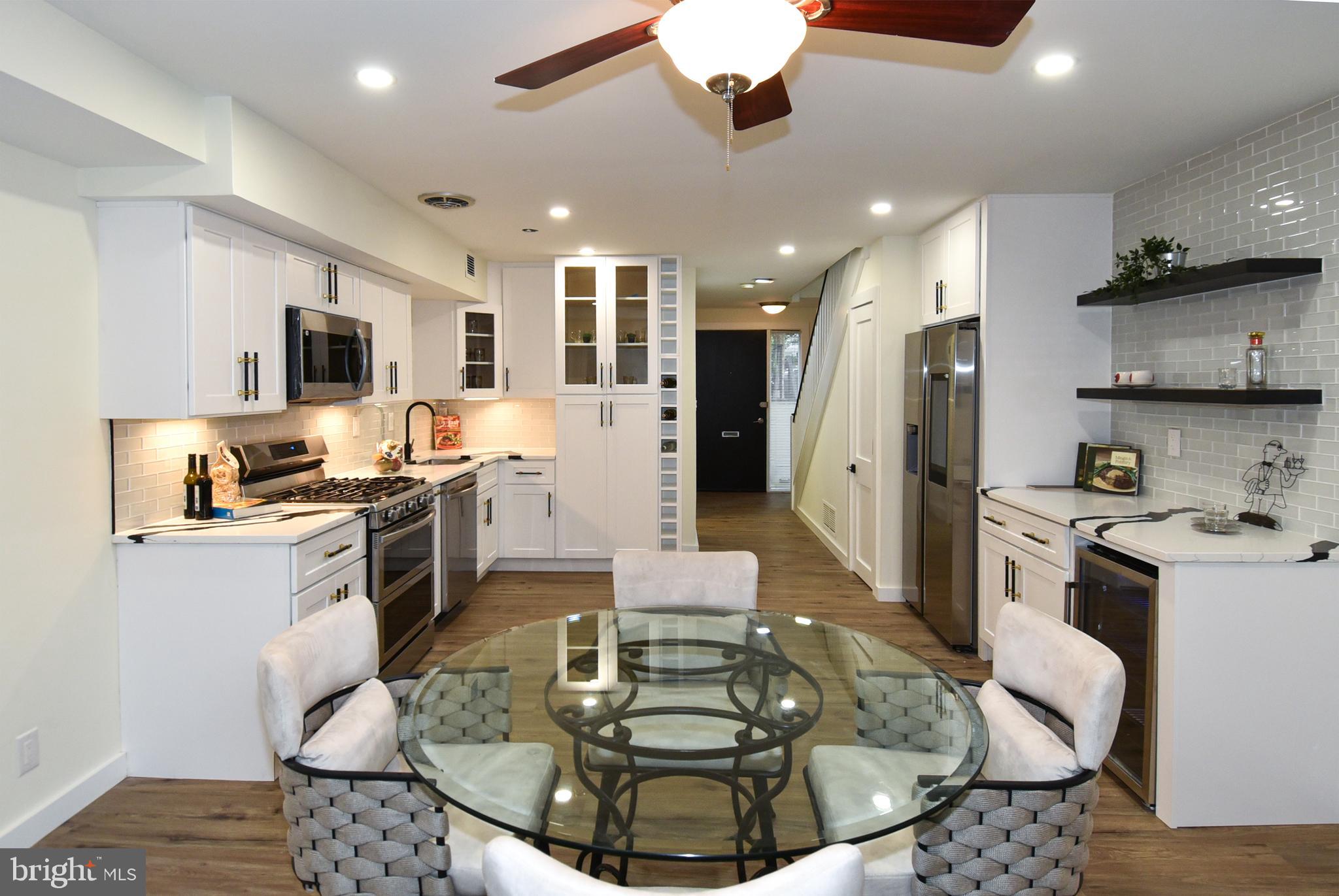 a kitchen with stainless steel appliances kitchen island granite countertop a sink and a refrigerator