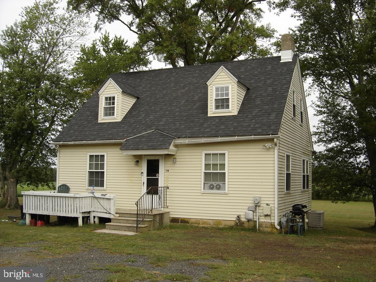 a front view of house with yard and trees in the background