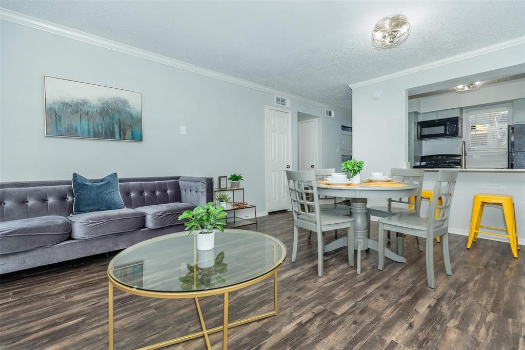 a living room with furniture a flat screen tv and a dining table