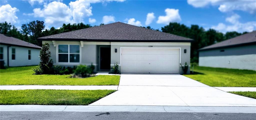 a front view of house with garage and yard