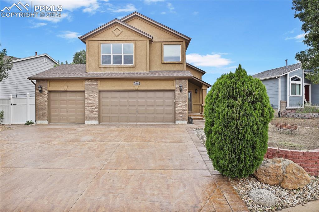 a front view of a house with a yard and garage