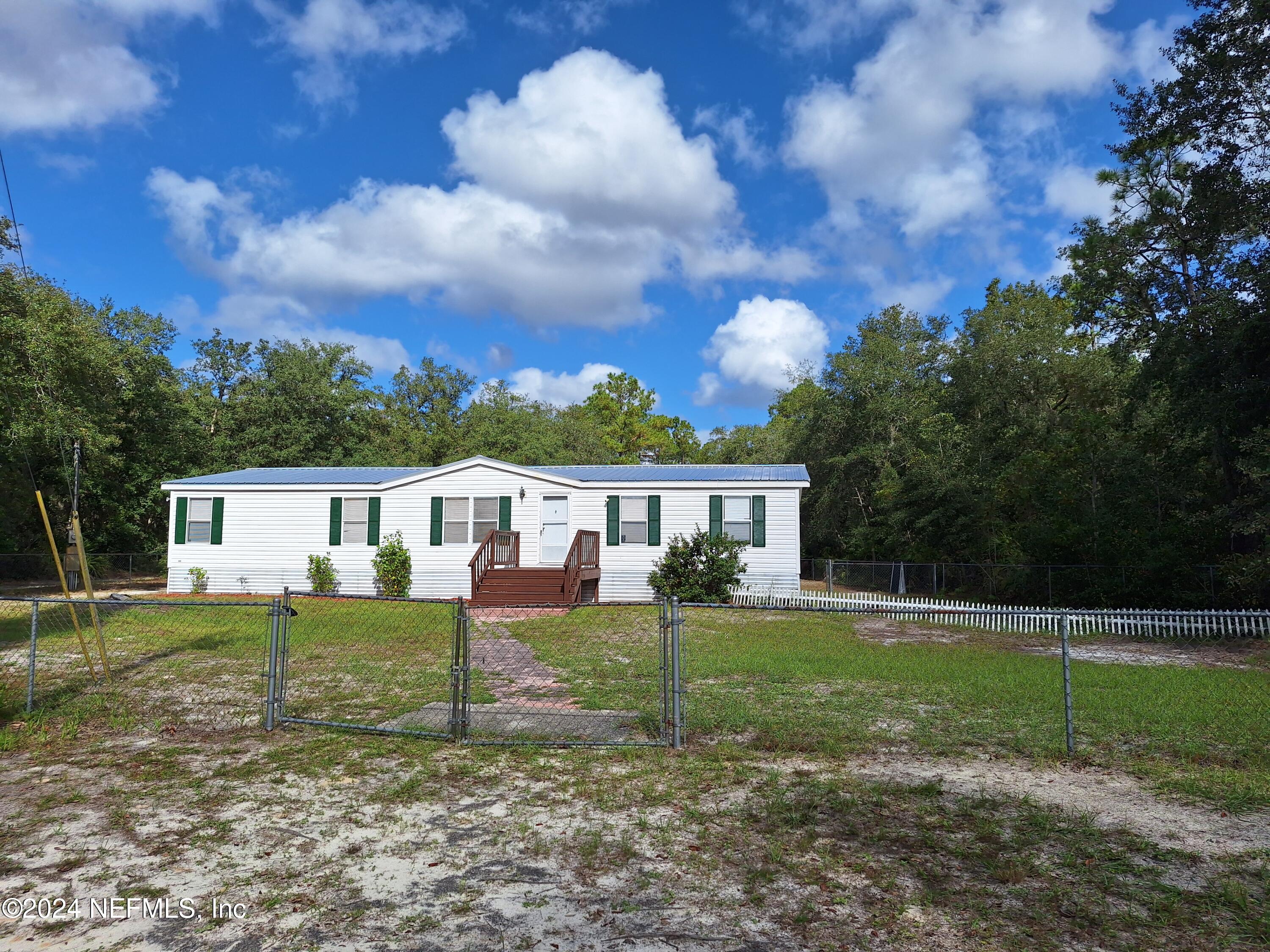 a view of a house with backyard and a tree