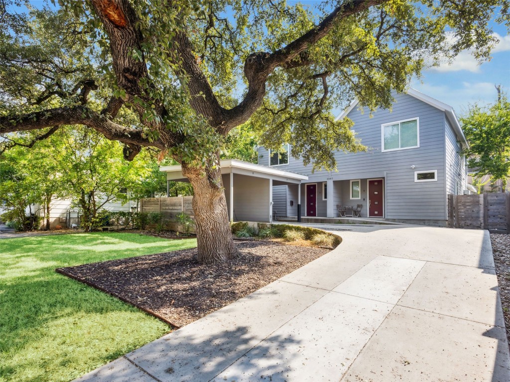 a front view of a house with a yard and trees