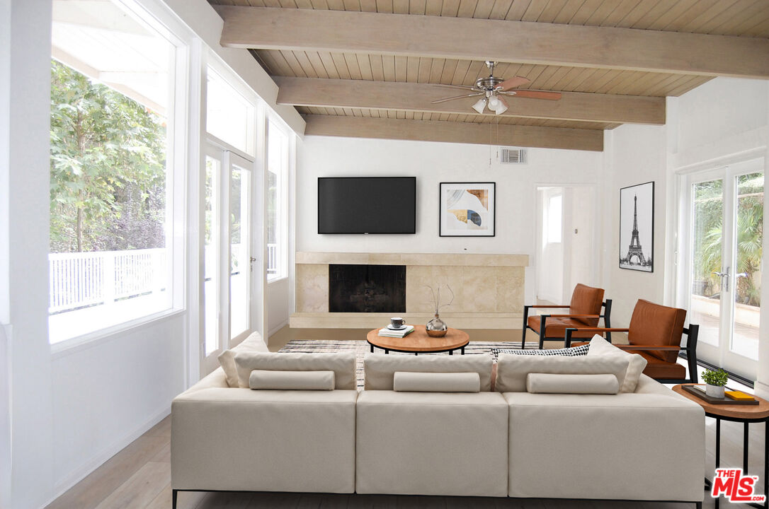 a living room with furniture a flat screen tv and a fireplace