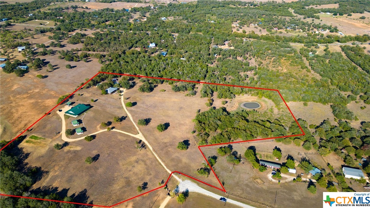 an aerial view of a house with a yard and lake view