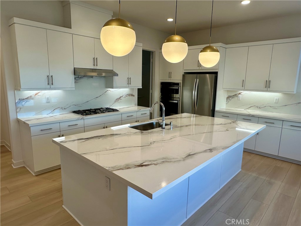 a kitchen with kitchen island a sink a stove and a wooden floors