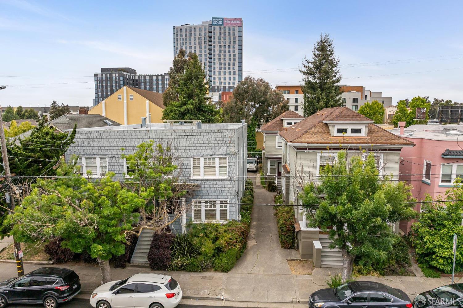 a front view of a residential apartment building with a yard and parking spaces