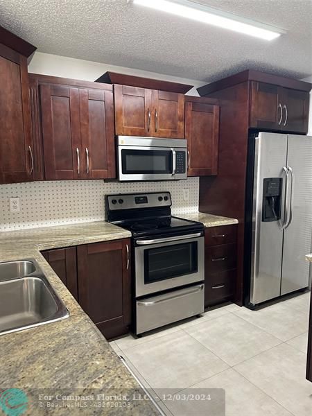 a kitchen with wooden cabinets and stainless steel appliances