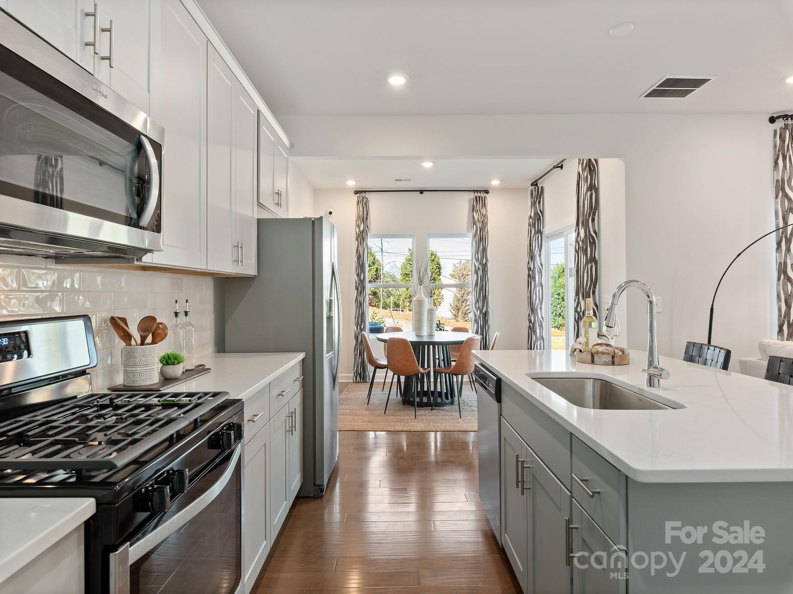 a kitchen with stainless steel appliances granite countertop a sink stove and refrigerator