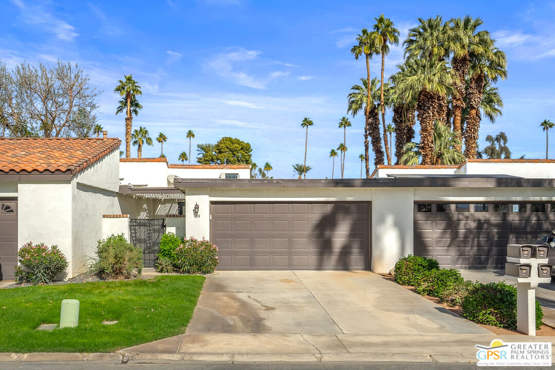 a front view of a house with a yard and potted plants