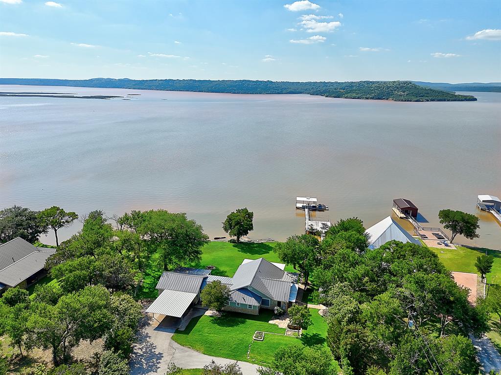 an aerial view of a house with a yard and lake view