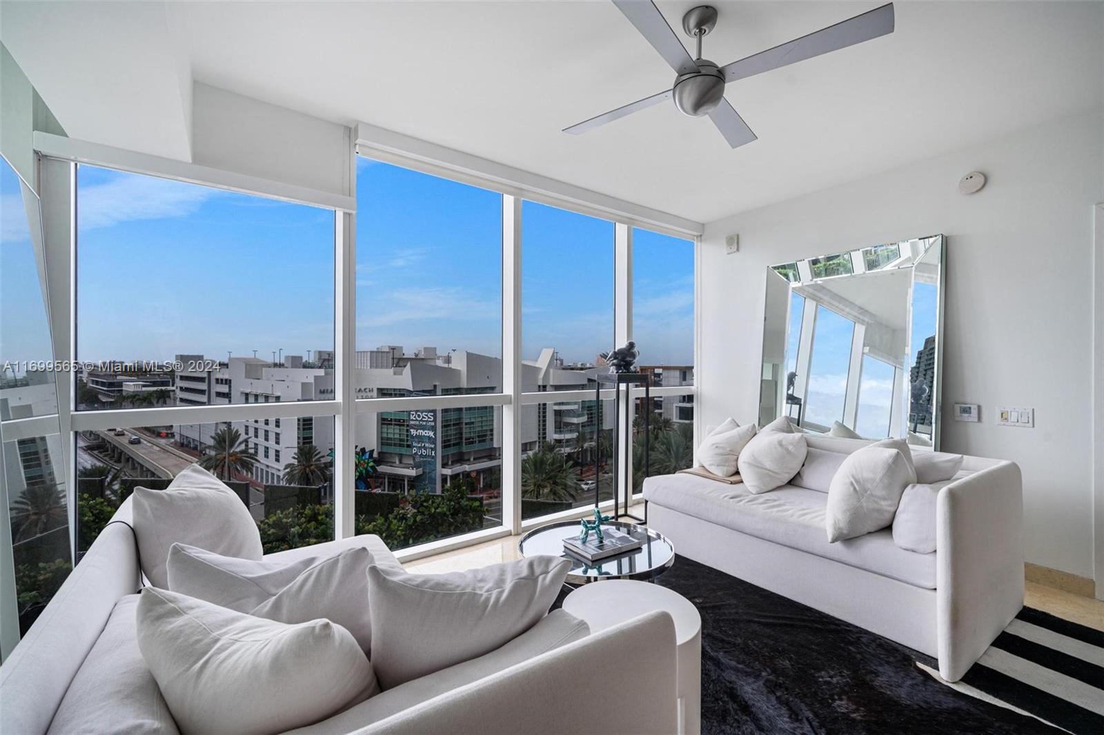 a living room with furniture and a floor to ceiling window