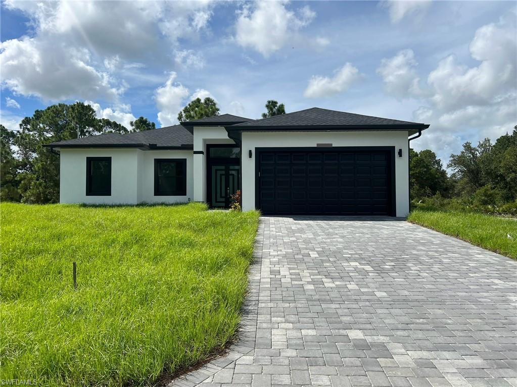 a front view of a house with a yard and garage