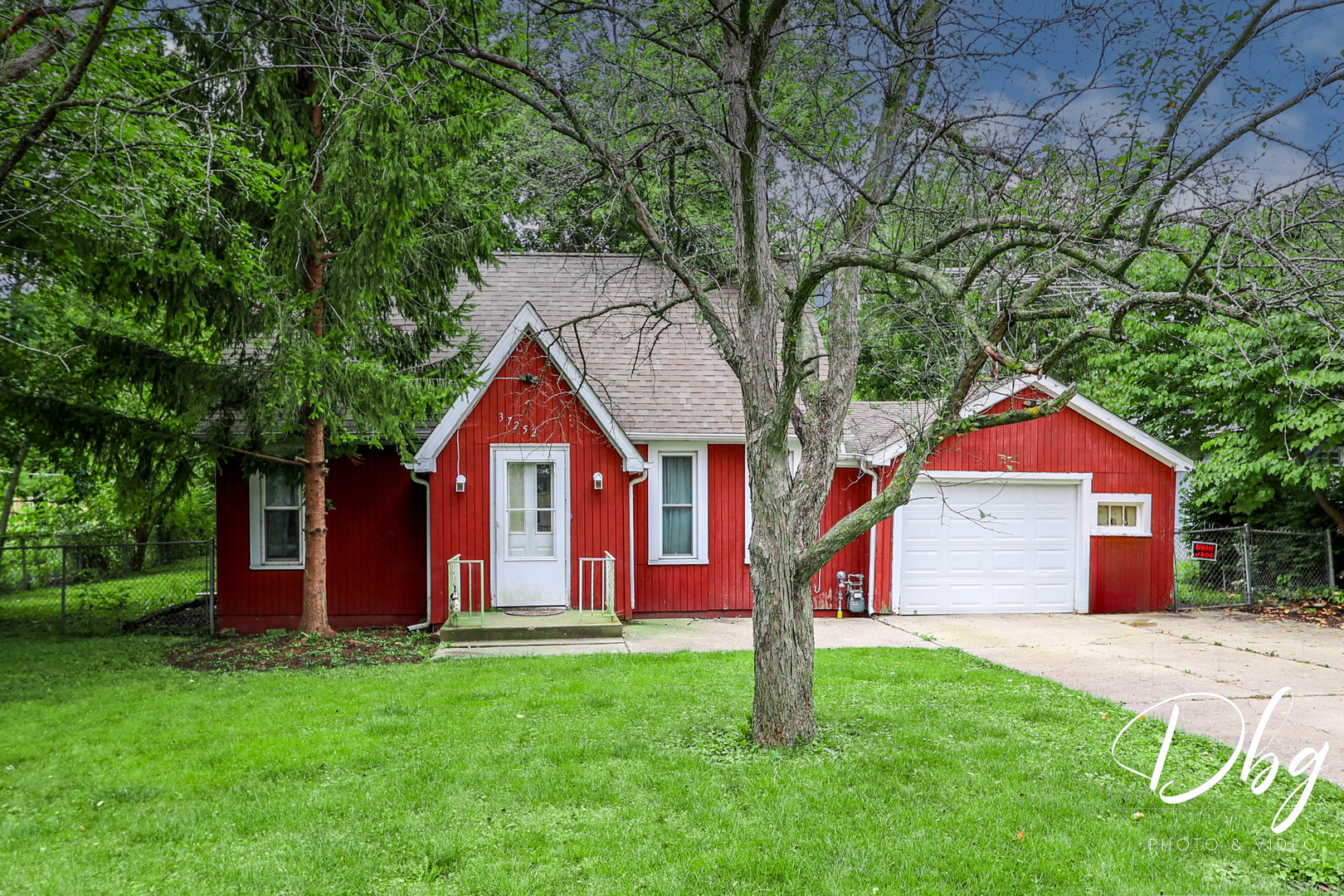 a front view of a house with a yard and tree