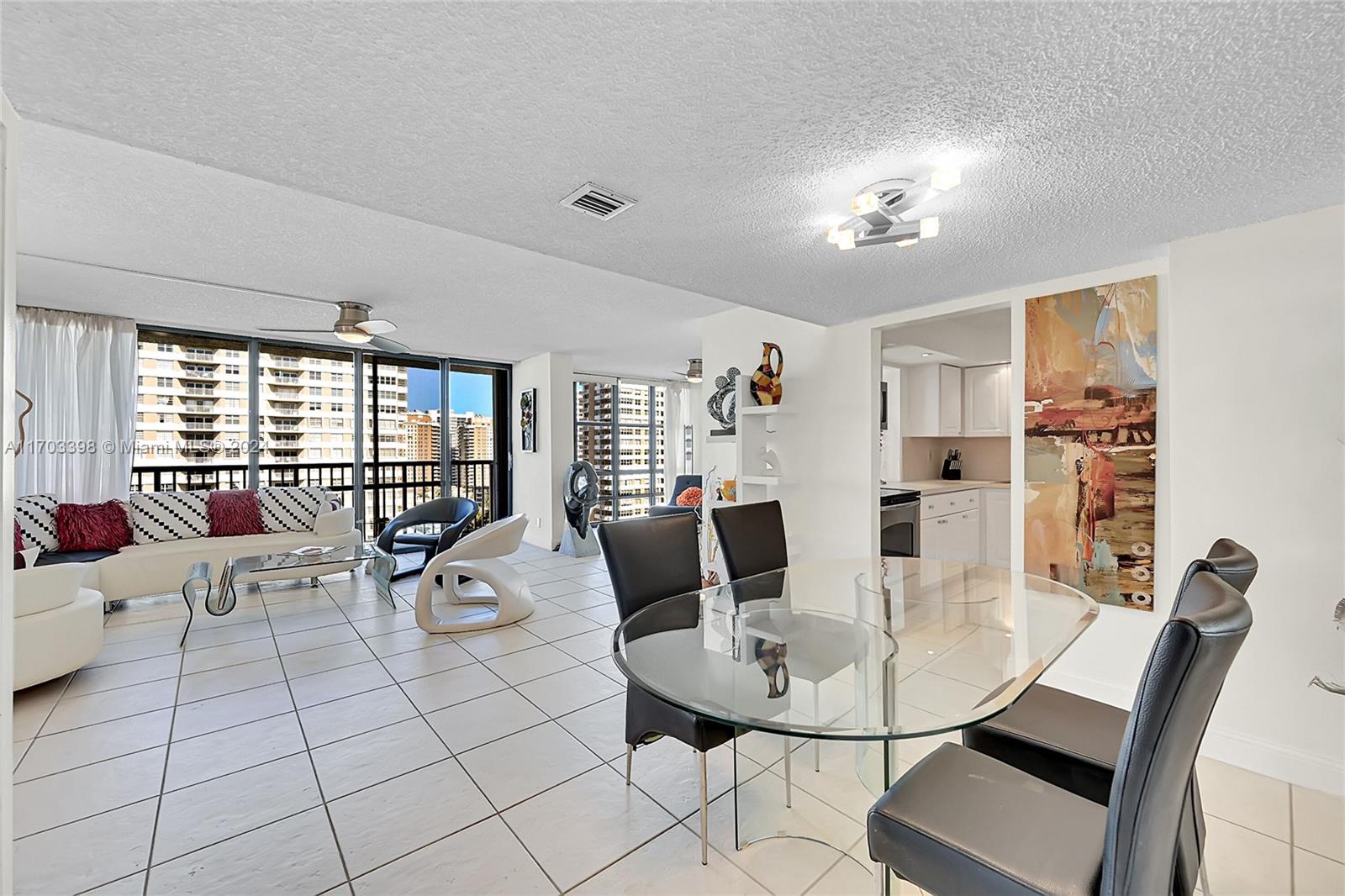 a living room with furniture and a dining table with chairs