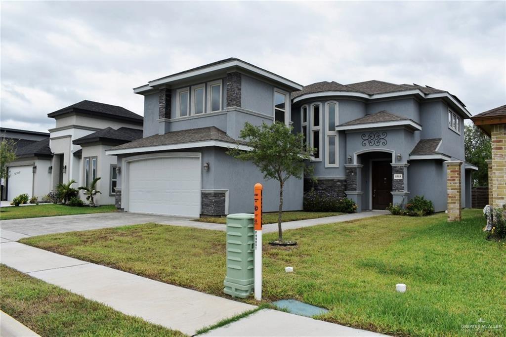 View of front of house with a front yard and a garage