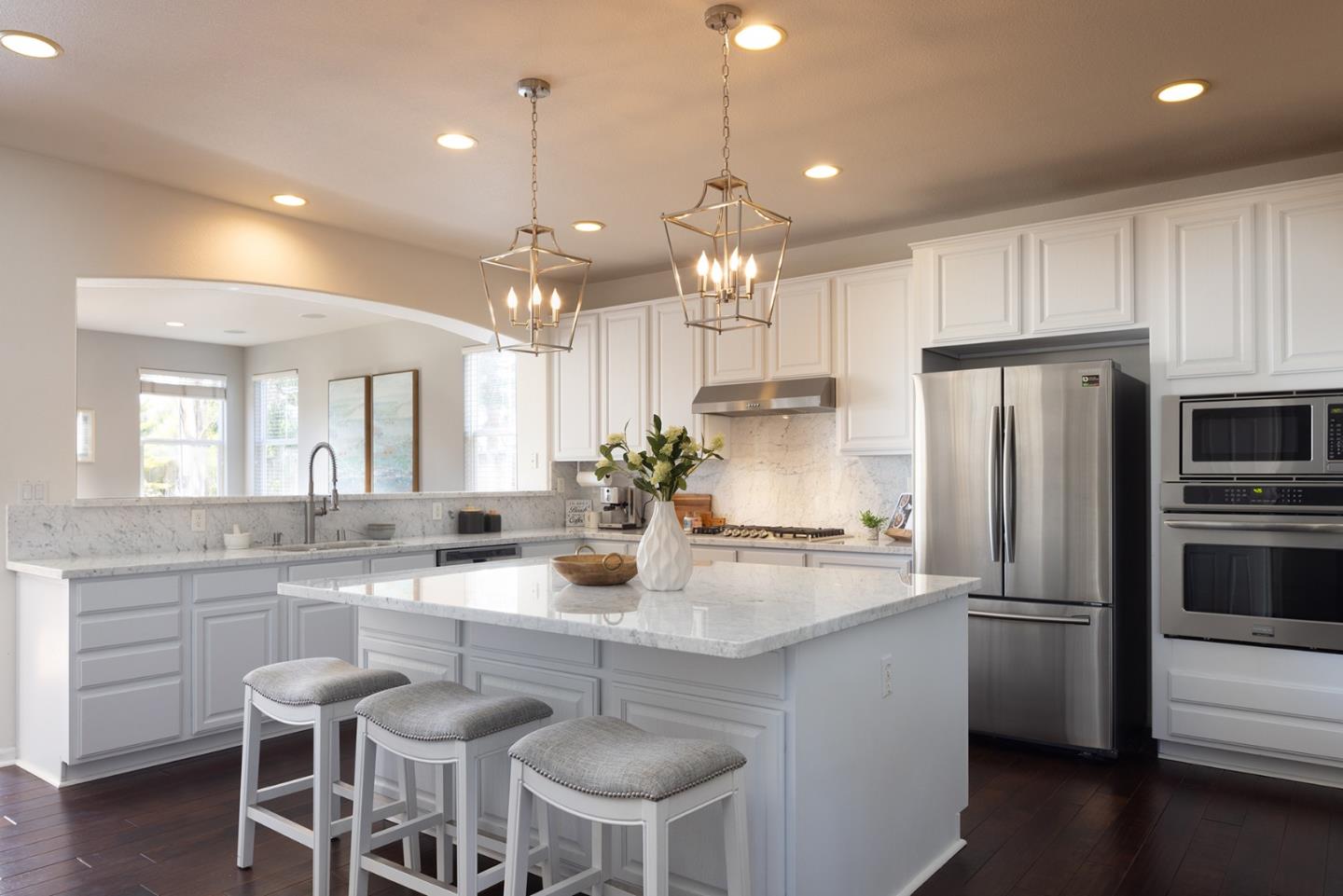 a kitchen with refrigerator a sink and chairs