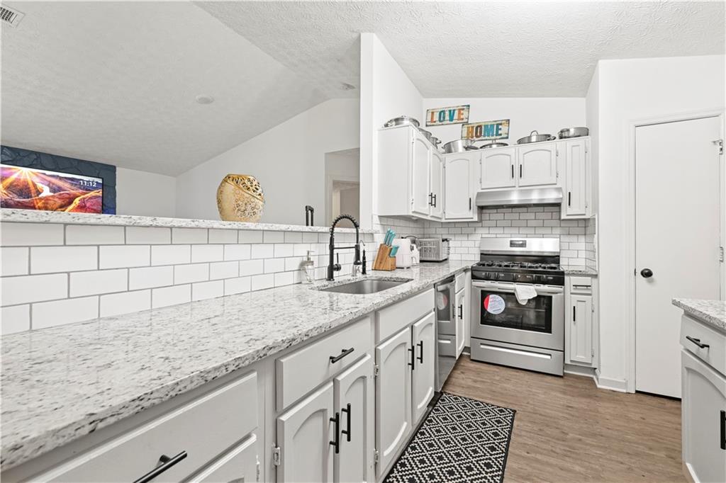 a kitchen with stainless steel appliances granite countertop a sink and cabinets