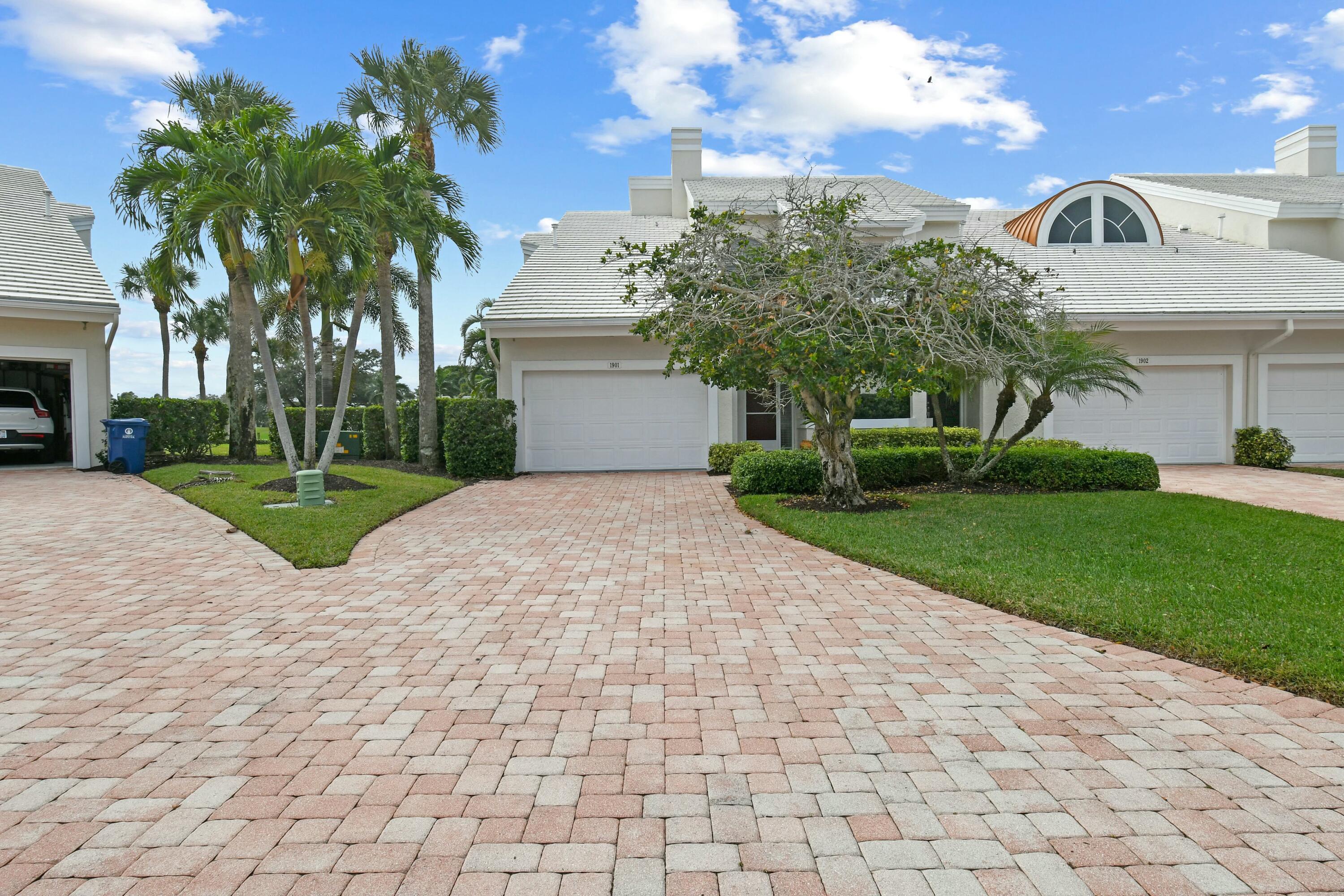 a view of a white house with a yard and potted plants