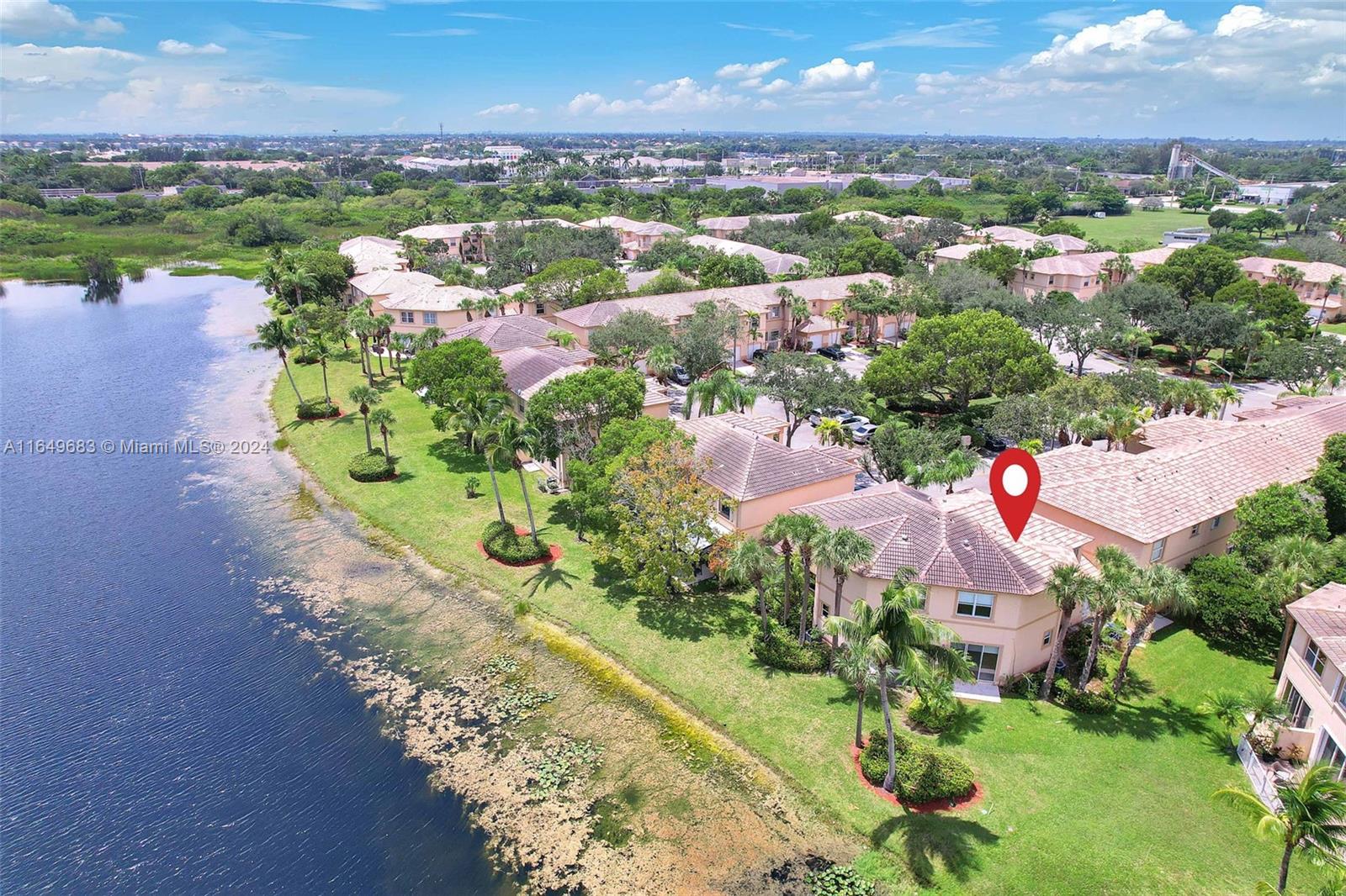 an aerial view of lake residential house with outdoor space and trees all around