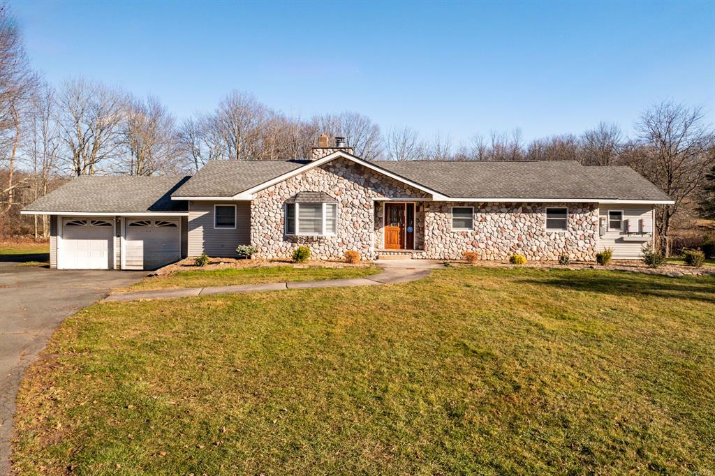 Single story home featuring a garage and a front yard