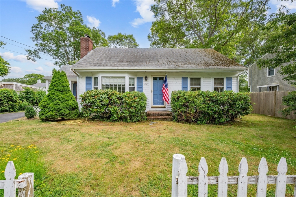 a front view of house with yard and trees