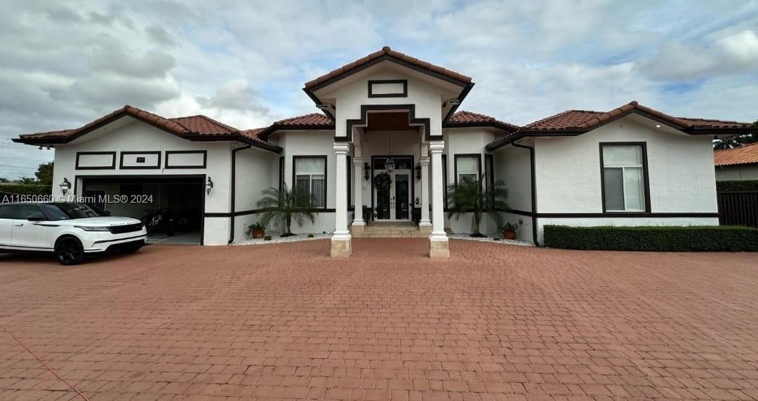 a view of a house with a yard and parking space