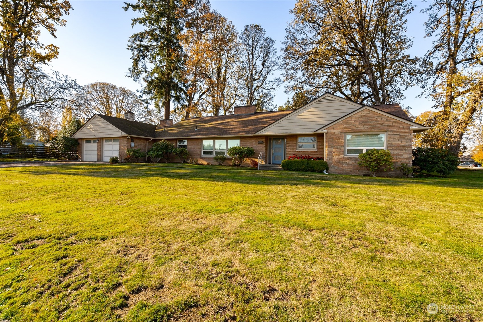 a front view of a house with swimming pool and trees in the background