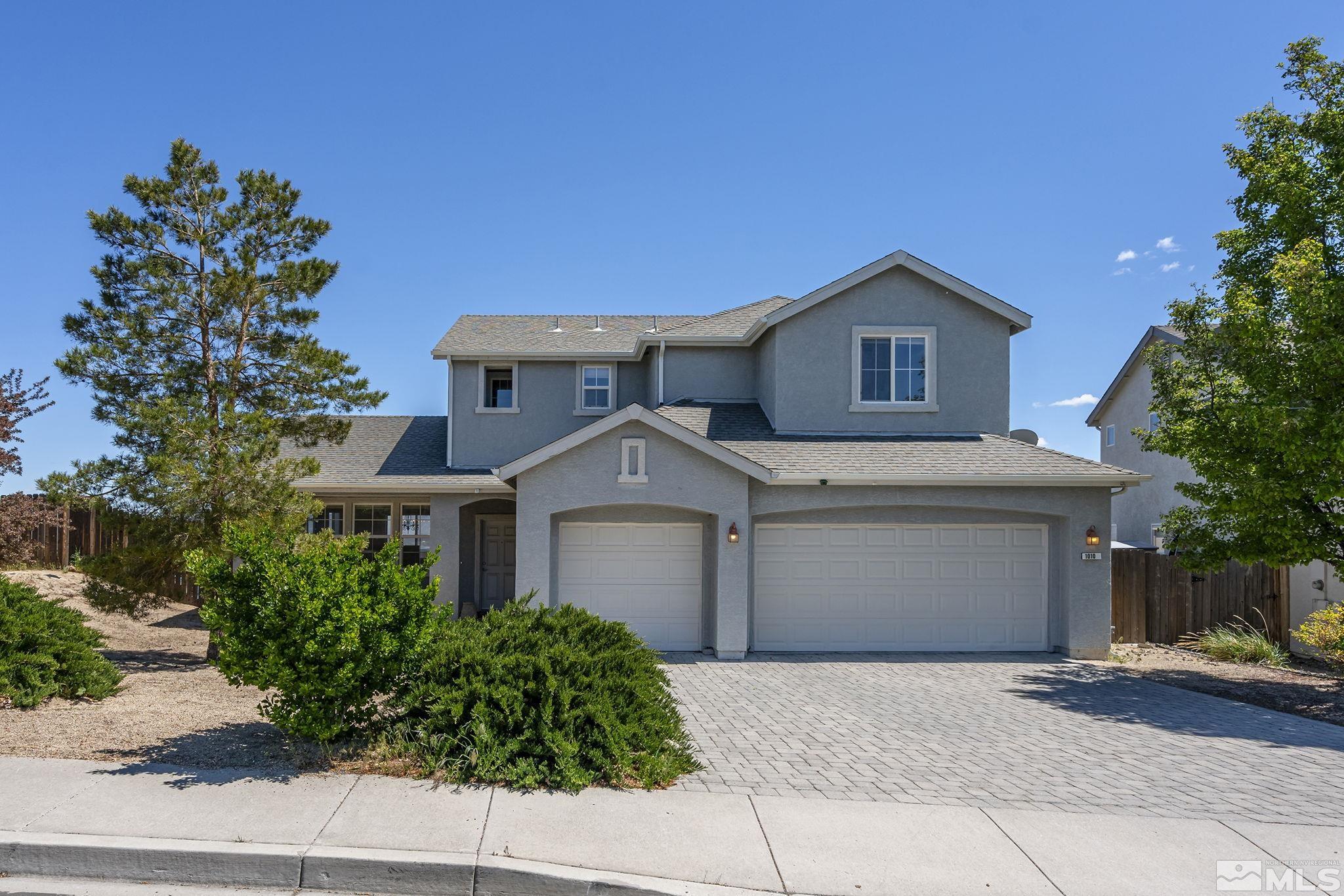 a front view of a house with a garden and garage