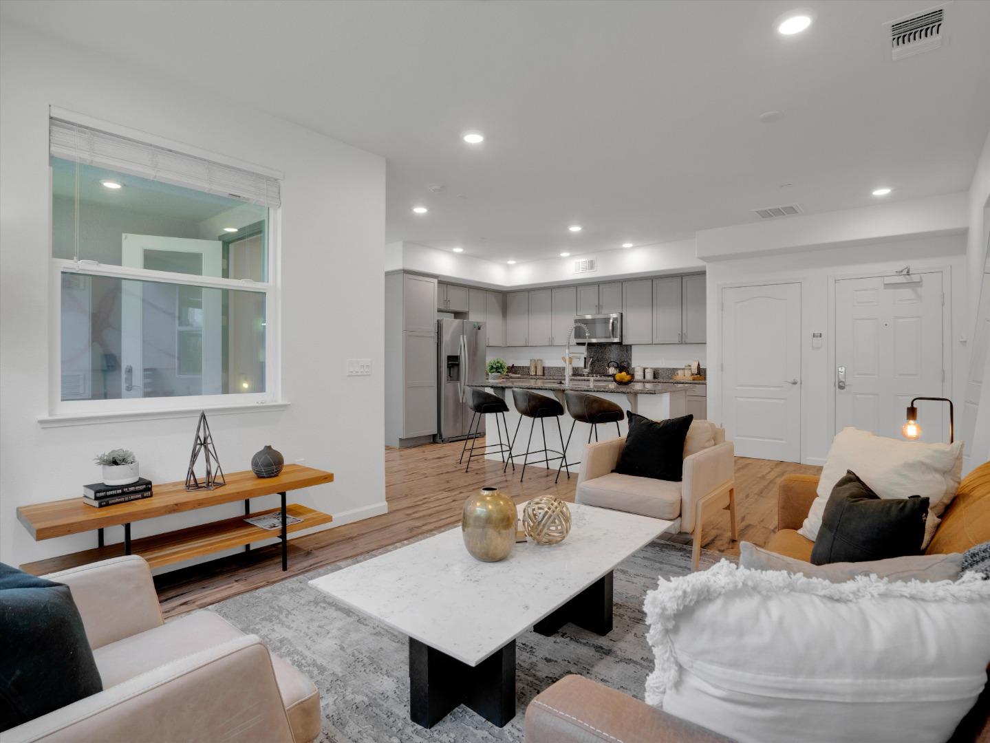 a living room with furniture and a dining table with kitchen view