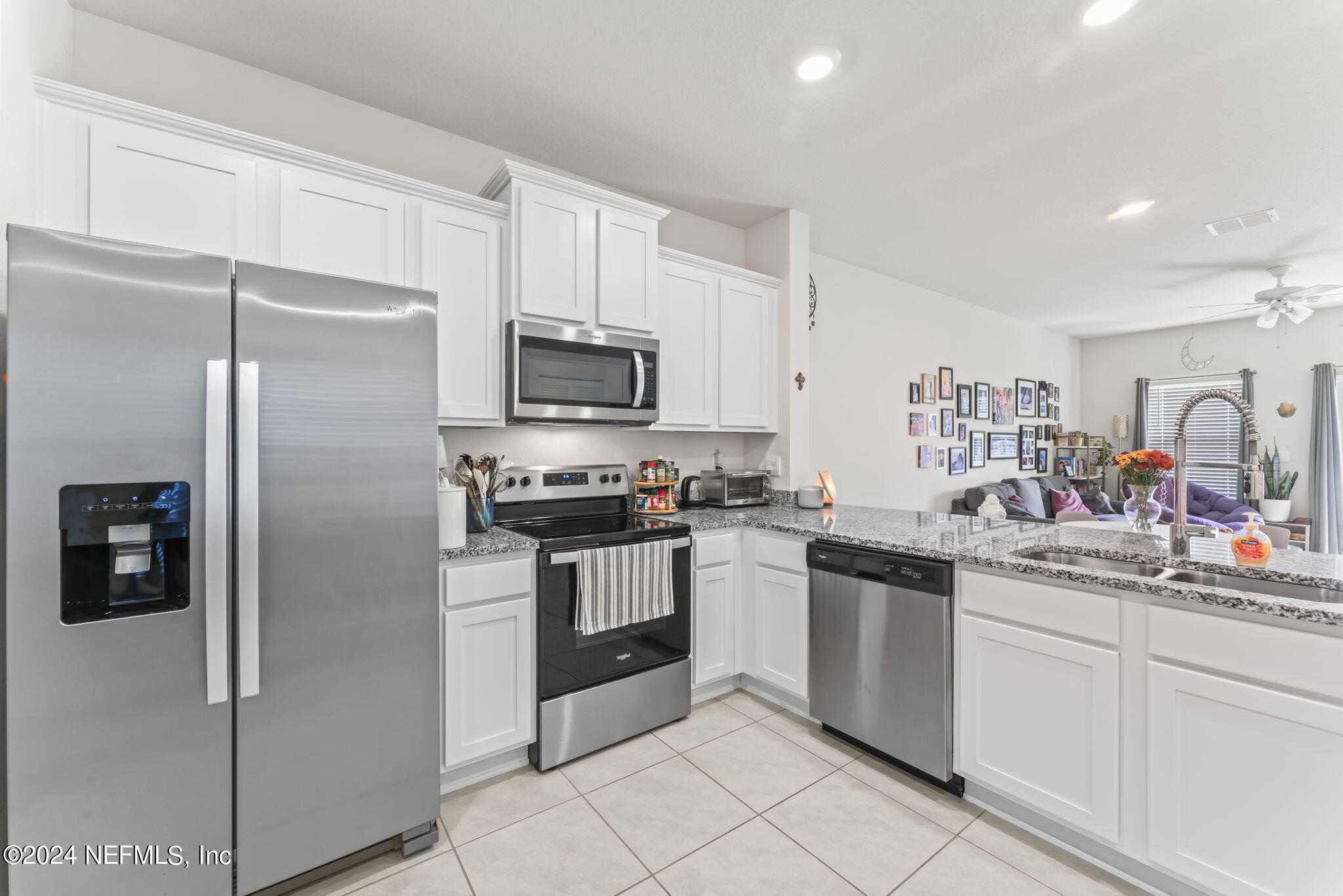 a kitchen with white cabinets stainless steel appliances and a sink