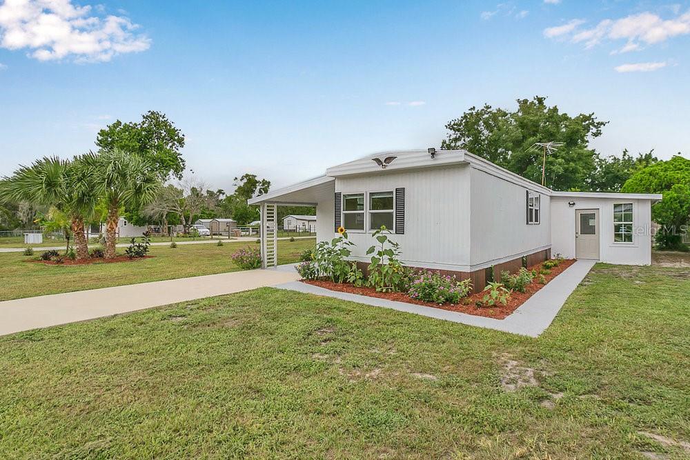 a view of a house with a yard and a patio