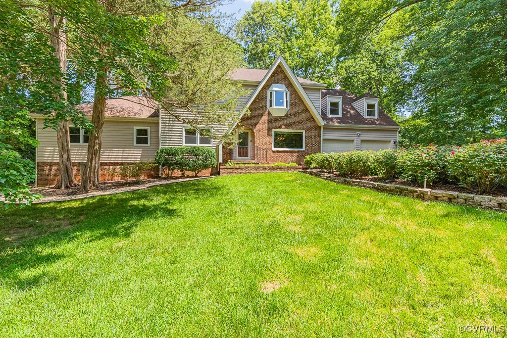 a front view of a house with a yard and trees